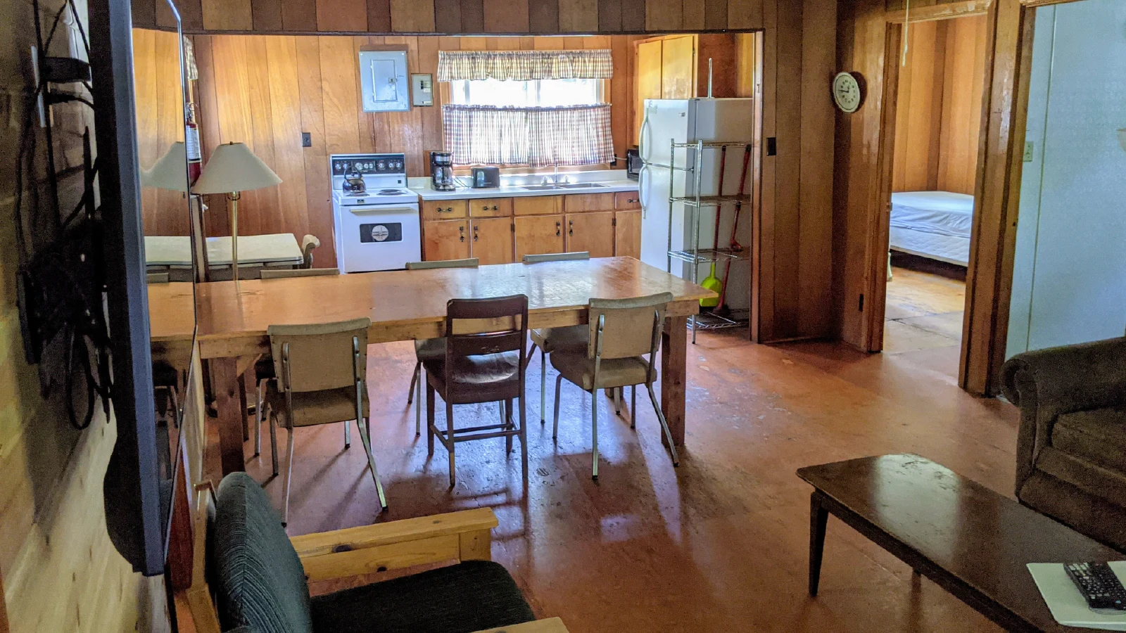 Pigeon Lake Resort Cottage three dining area connected to kitchen with table, stove, sink, and refrigerator.